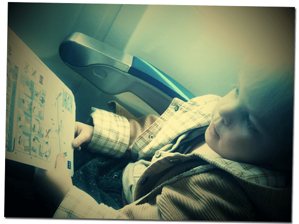 Lucien reading the safety instruction on our flight to the UK.