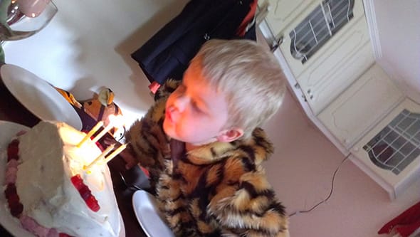 Lucien blowing out the four candles on his birthday cake.
