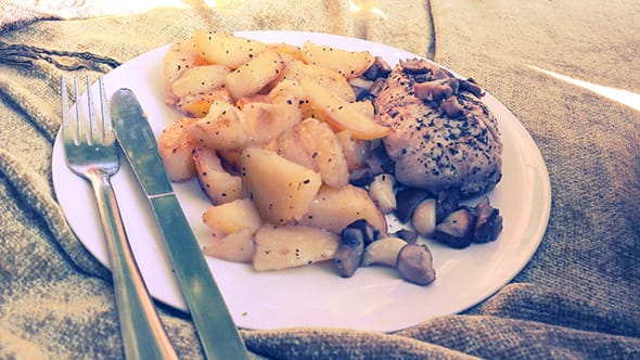 A plate of roasted potatoes, chicken breasts and roasted mushrooms.