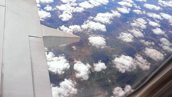 The view from inside the plane to Finland, souring over the clouds.