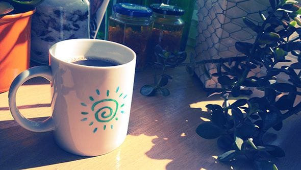 A coffee mug brightly lit by the morning sun.