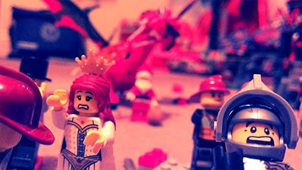 Lego minifigures running in terror as Lego santa and the Lego dragon attacks them, breathing fire everywhere.