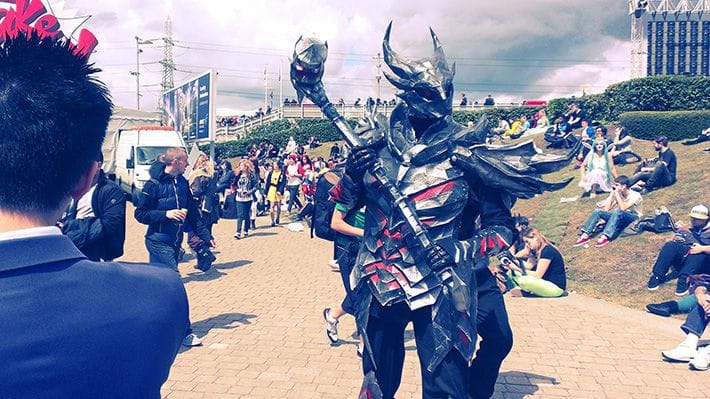 A cosplayer in a full set of Daedric Armor, from The Elder Scrolls series, with Daedric Warhammer.
