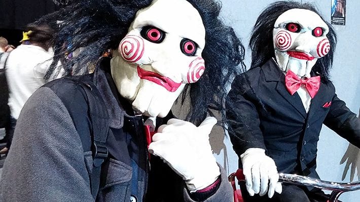 Billy the Puppet (from the Saw film series) pointing at a puppet of himself