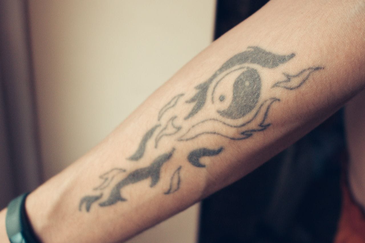 A simple tribal tattoo with a Yin and Yang symbol in the middle.