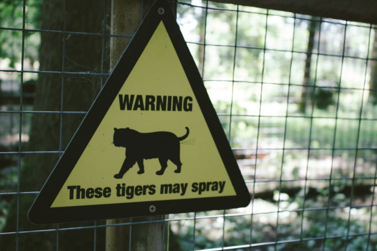 Sign warning for spraying tigers.