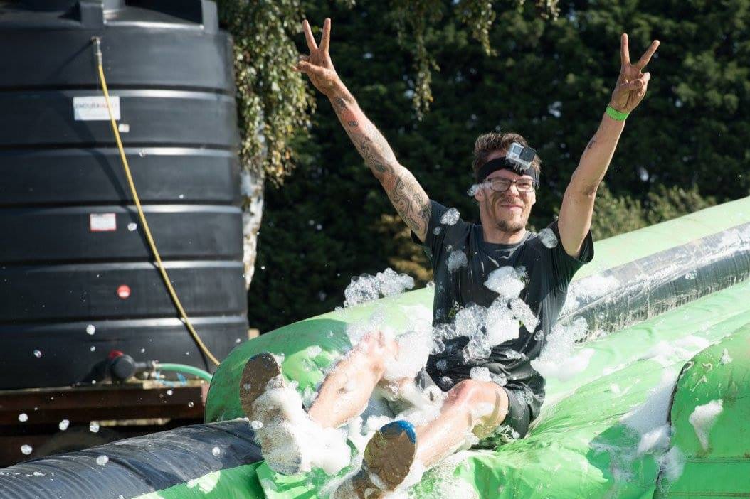 Carlos Eriksson sliding through foam and fairy liquid, giving the victory sign.