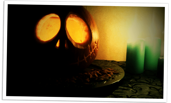A carved pumpkin, under candle light.