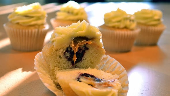 A cupcakes cut through, revealing its gooey Blackberry filling.