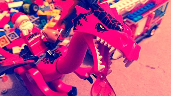 Lego santa riding on a large red Lego dragon.