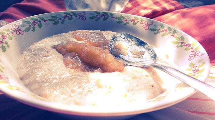 A bowl of oatmeal porridge with apple sauce