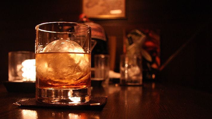A glass of whisky on the rocks in an English pub