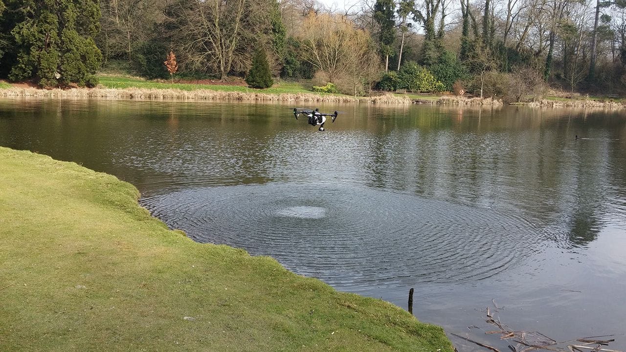DJI Inspire 1 Quadcopter hovering above water and creating ripples.
