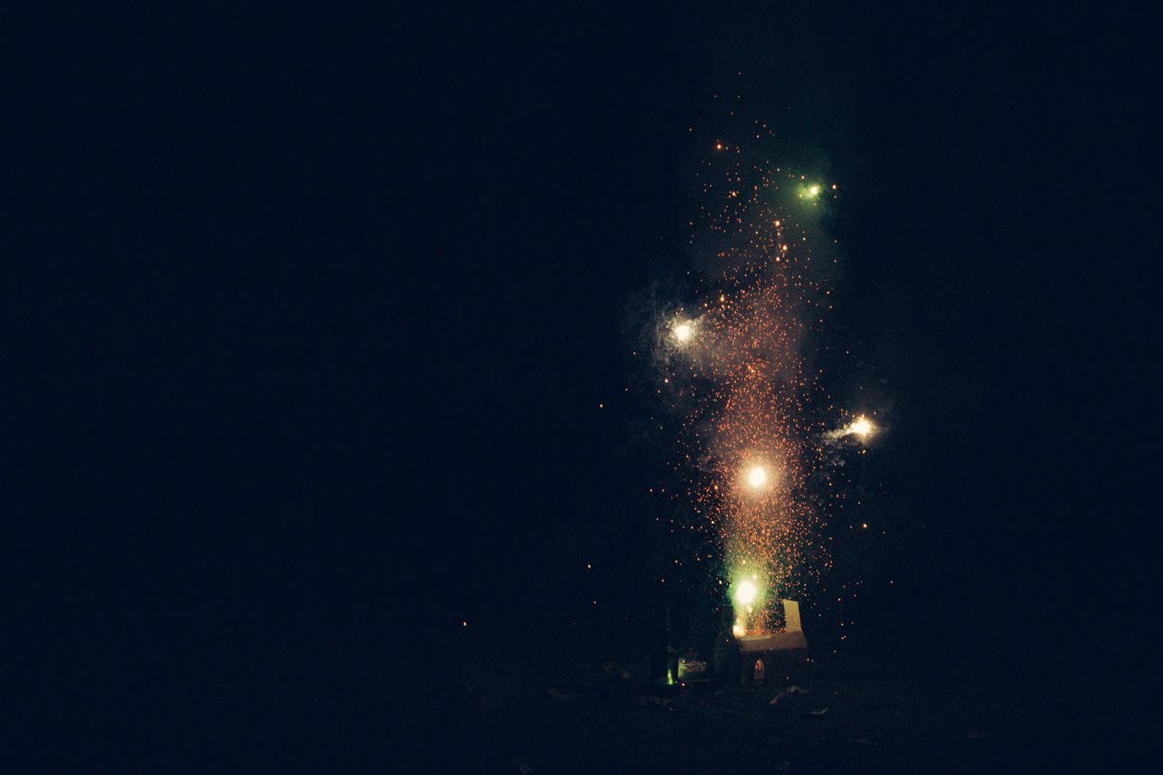 Fireworks shooting out of and illuminating the cardboard replica of the House of Lords.