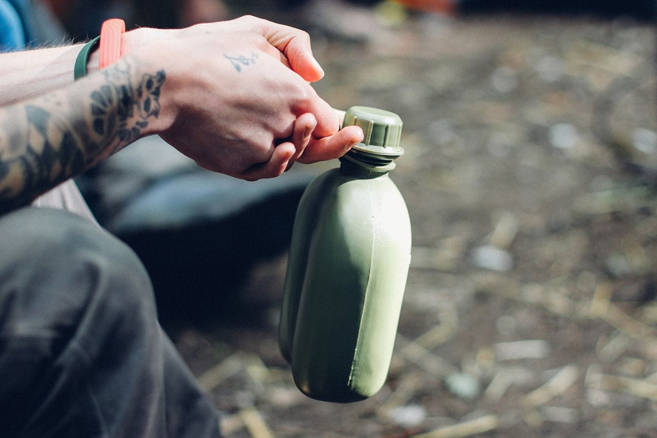 Close-up of me sitting and holding on to my water bottle by its plastic loop.