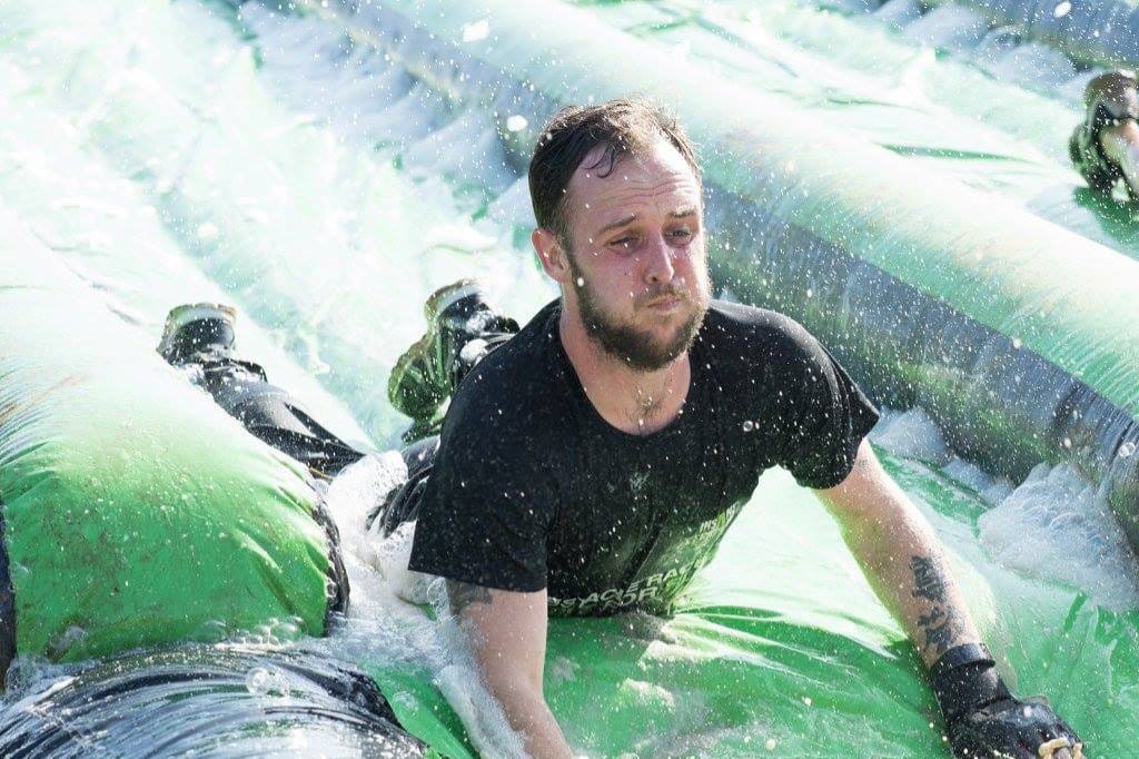 Scott Mokler sliding through foam and fairy liquid, head first into a pool of water.