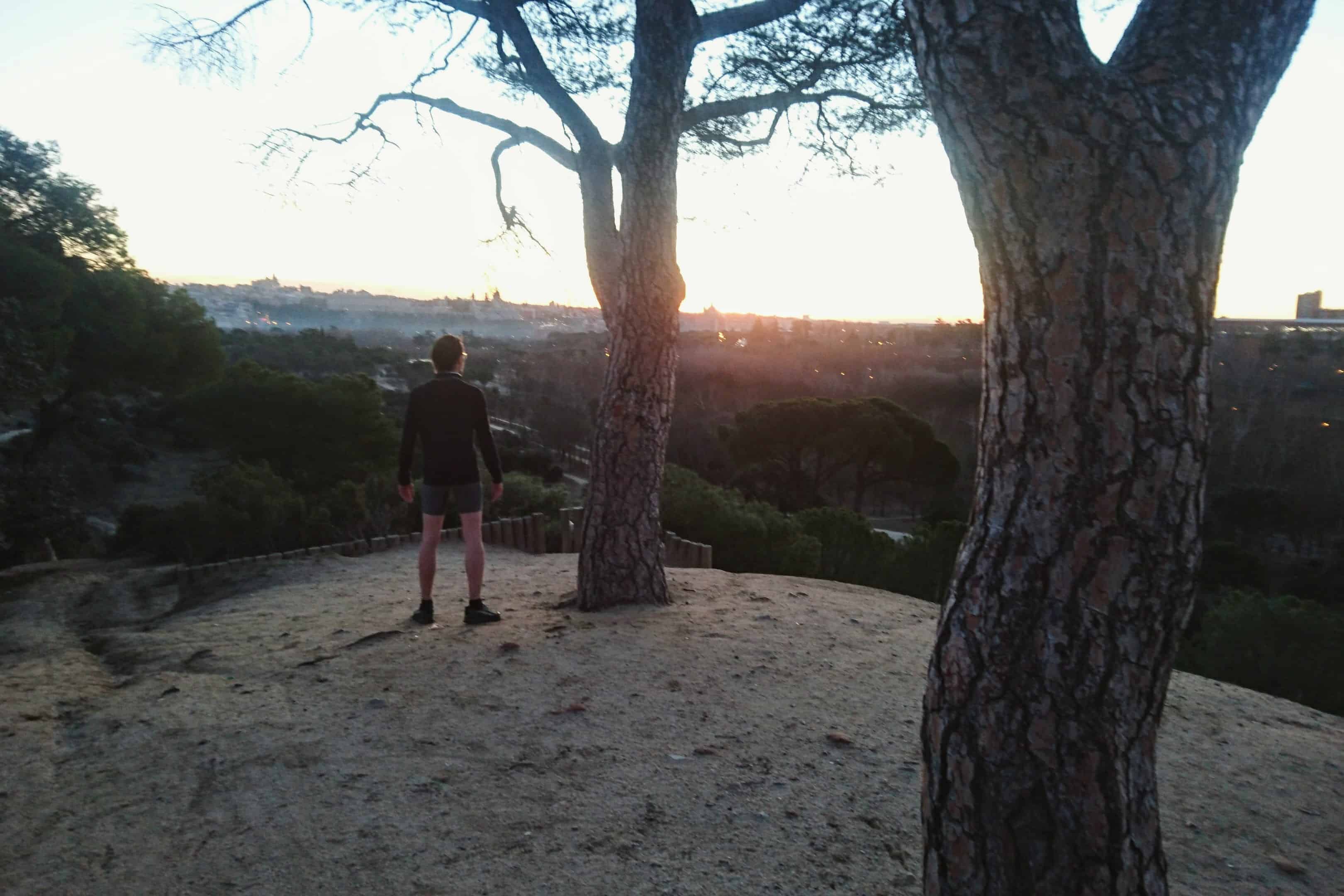 Carlos Eriksson standing and overlooking the sunrise from the hilltops of Casa de Campo, Madrid, Spain.