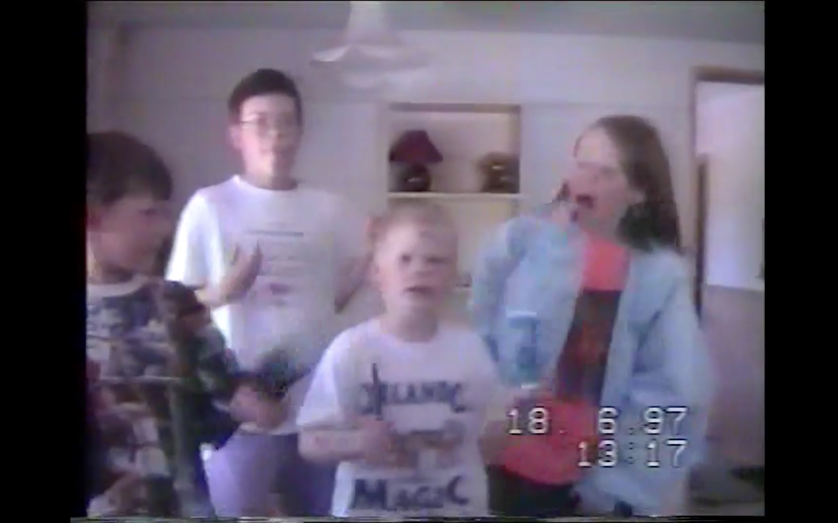 A still frame captured from a 26-year-old VHS recording of me and my siblings playing air-instruments and miming to a song.